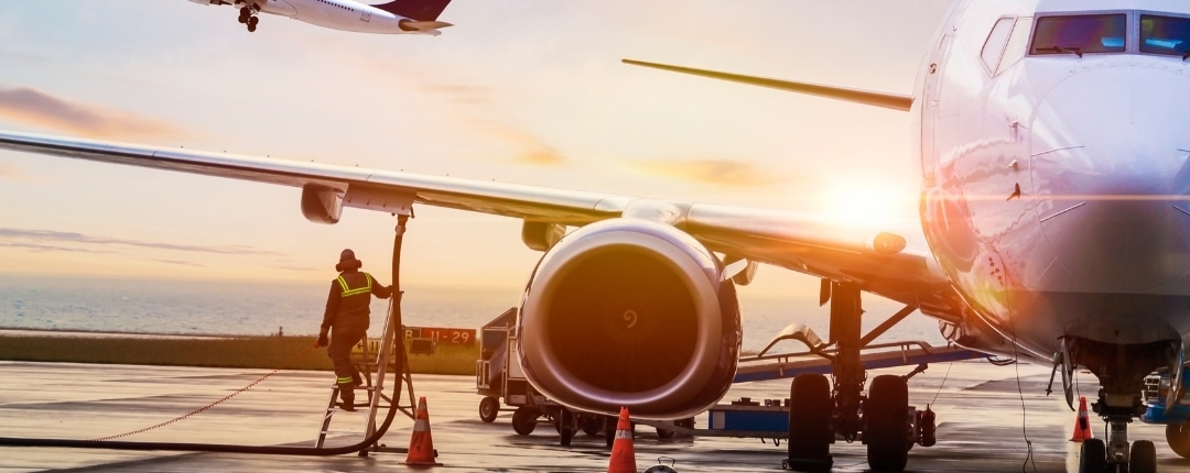 Aircraft being refueled on runway at sunrise, symbolizing international travel and expatriate movement.