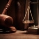 A wooden gavel next to a brass scale, symbolizing justice and legal matters, with a focus on the Tax Amendment Bill's legal implications and penalties.