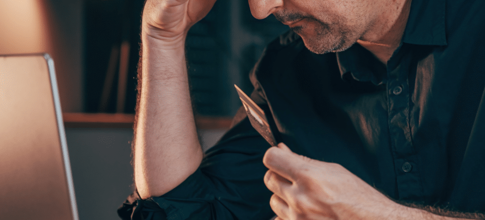 Stressed man reviewing finances on laptop, concerned about issues with foreign bank account and SARS tax refunds. - foreign bank account