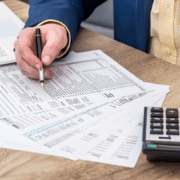 Businessman works with tax form, laptop and calculator