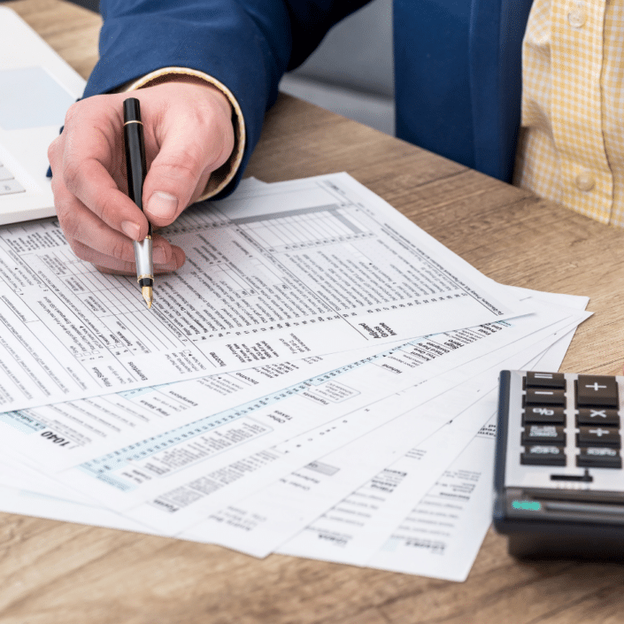 Businessman works with tax form, laptop and calculator