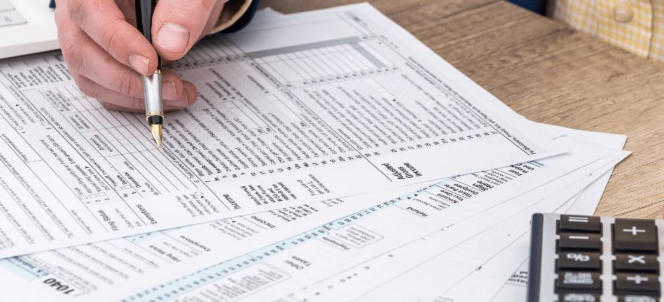Businessman works with tax form, laptop and calculator